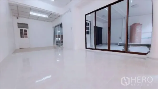 Townhouse for sale - Open-plan living space with glossy tiles and glass partition doors.