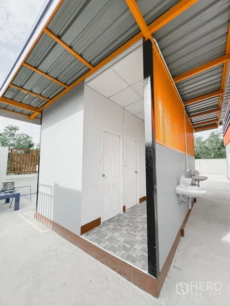 Warehouse for rent or sale in Khlong Luang, Pathum Thani - External restroom and service block with sinks and tiled floor under a metal awning.