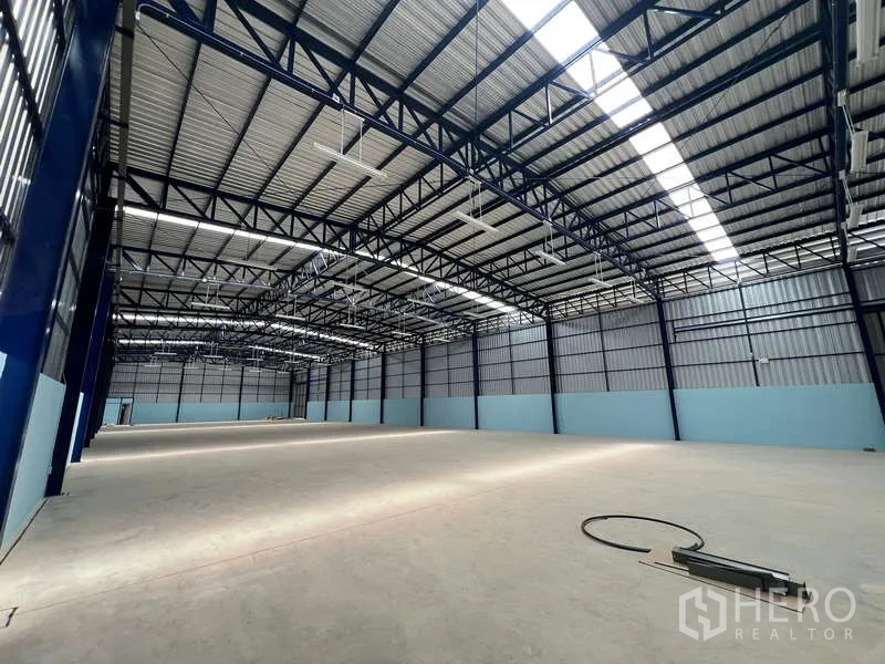 Warehouse for rent in Lat Krabang, Bangkok - Spacious high-clearance warehouse interior with steel trusses and skylights.