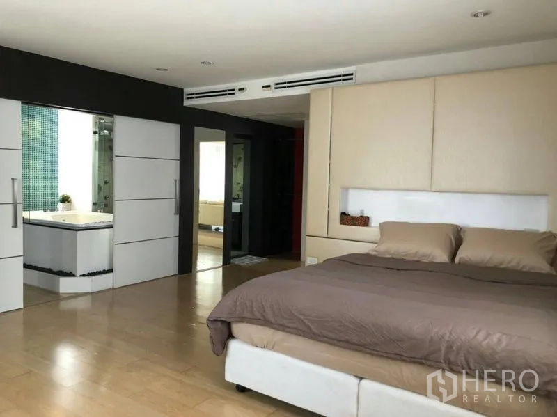 Condominium for rent or sale in Watthana, Bangkok - Master bedroom view toward ensuite bathroom showing the jacuzzi behind sliding doors.