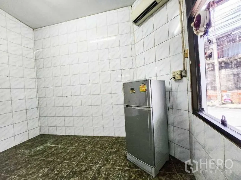 Home Office for rent in Khlong Toei, Bangkok - Compact tiled pantry with a refrigerator and a street-facing window.