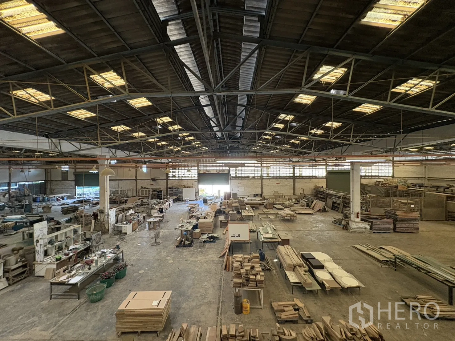 Factory for sale in Khlong Toei, Bangkok - Wide warehouse floor with machinery and roller shutter doors