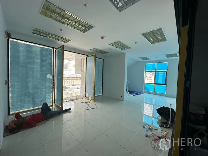 Factory for rent in Khlong Luang, Pathum Thani - Bright tiled office area with large windows and glass doors during fit-out.
