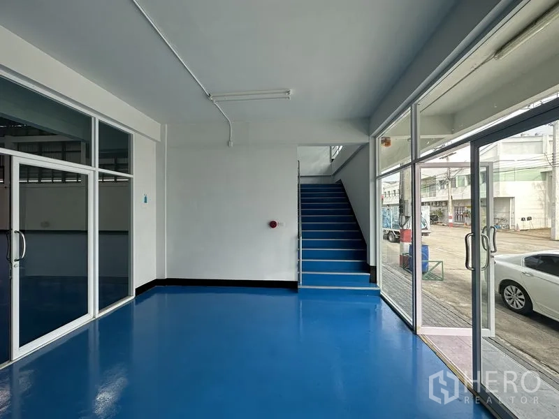工厂 出租在Khlong Luang, Pathum Thani - 一层接待区，玻璃推拉门与通往二层的楼梯。