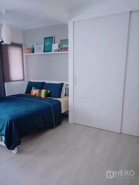 Townhouse for rent or sale in Khlong Toei, Bangkok - Cozy bedroom with display shelf and large white sliding wardrobe
