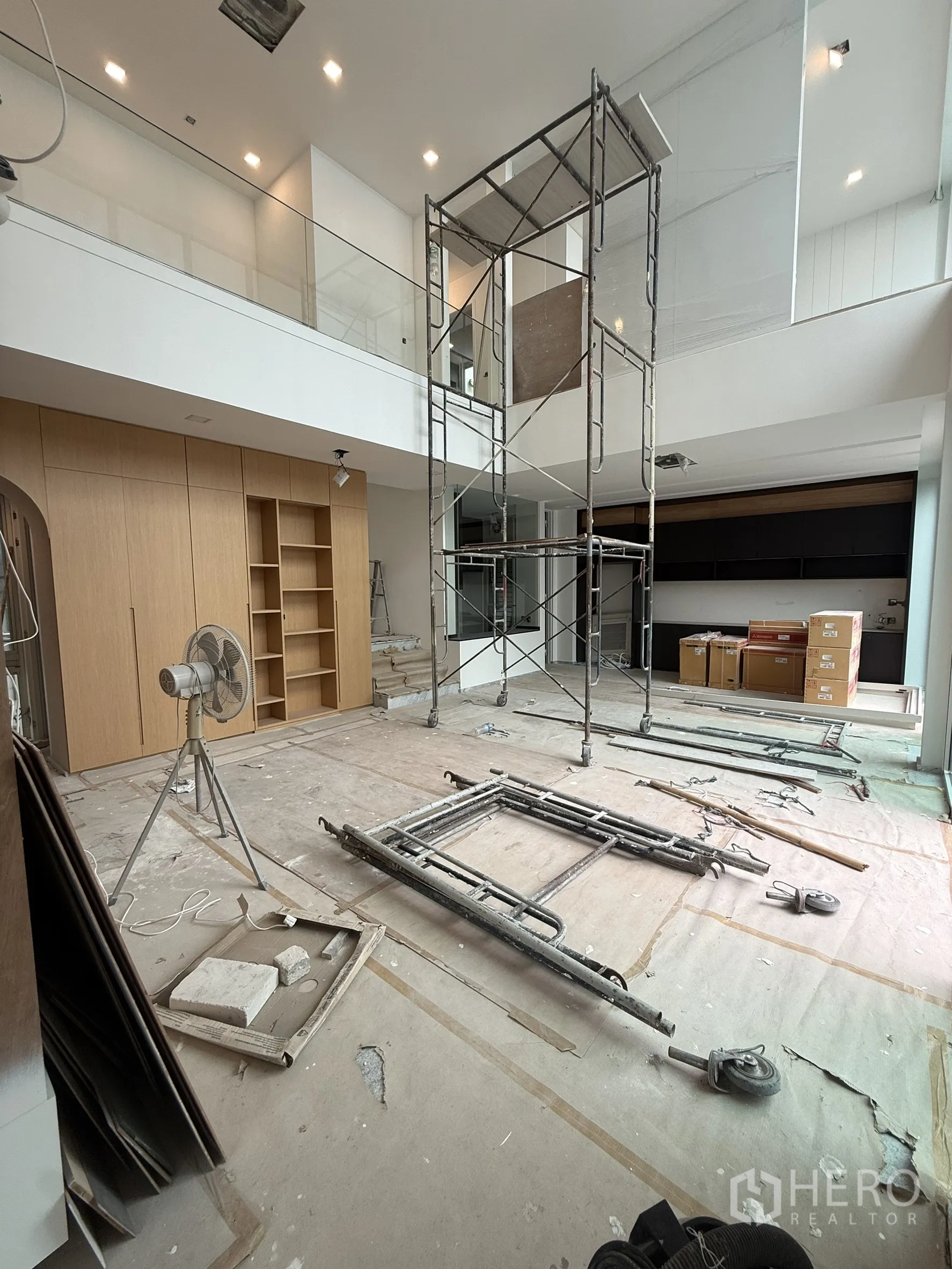 Detached House for sale in Bang Phli, Samut Prakan - Double-volume living space under construction with scaffold and glass balustrade.