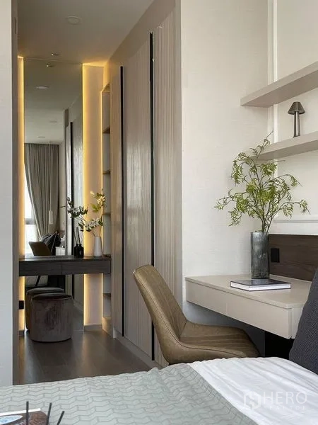 Condominium for rent in Pathum Wan, Bangkok - Bedroom work corner featuring a floating desk, chair and illuminated wardrobe corridor.