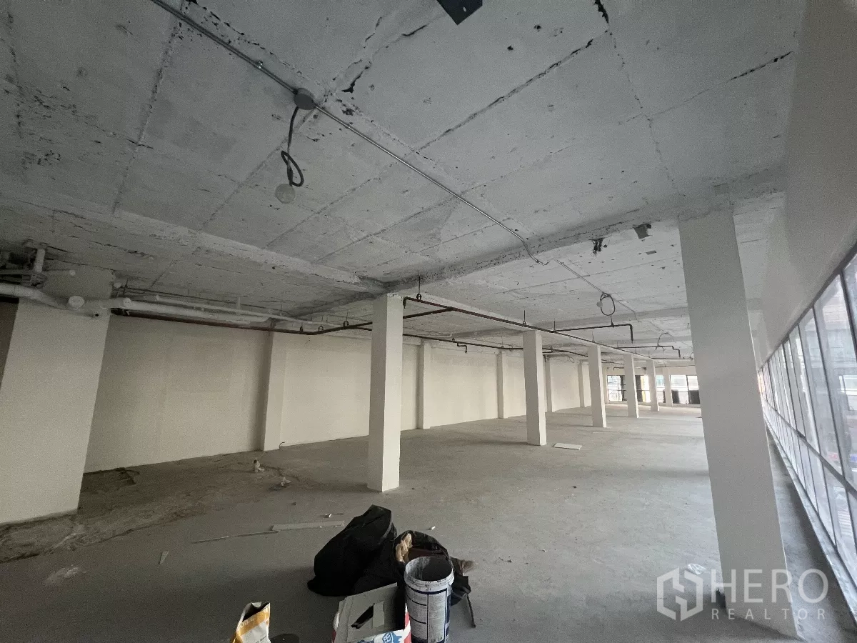 Retail Space for rent in Watthana, Bangkok - Large shell space with tools on the floor, showing work-ready condition.