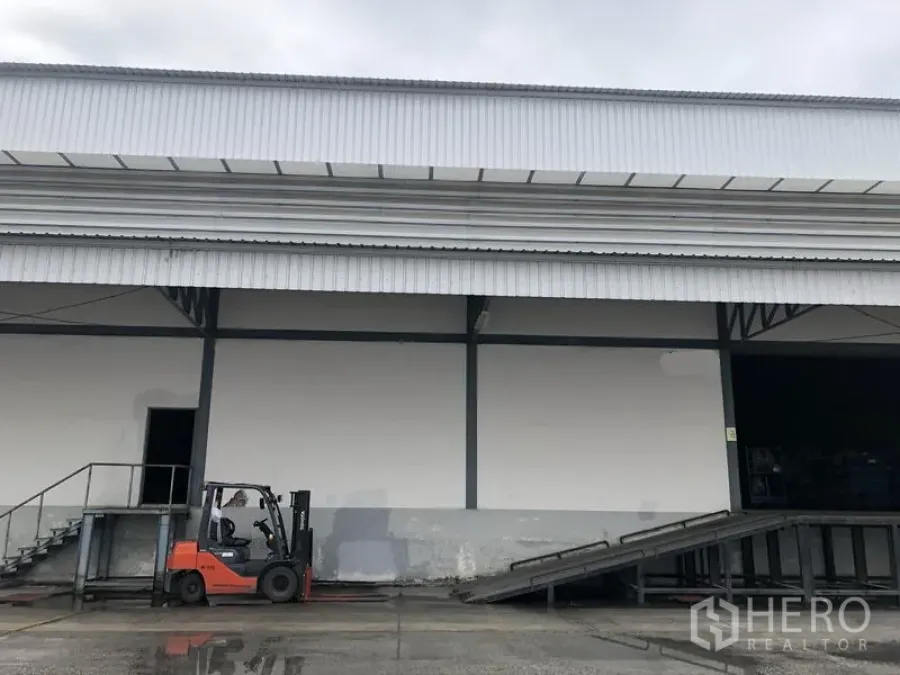 Warehouse for rent in Bang Phli, Samut Prakan - Loading bay with forklift and drive-up ramp beside a modern warehouse facade.