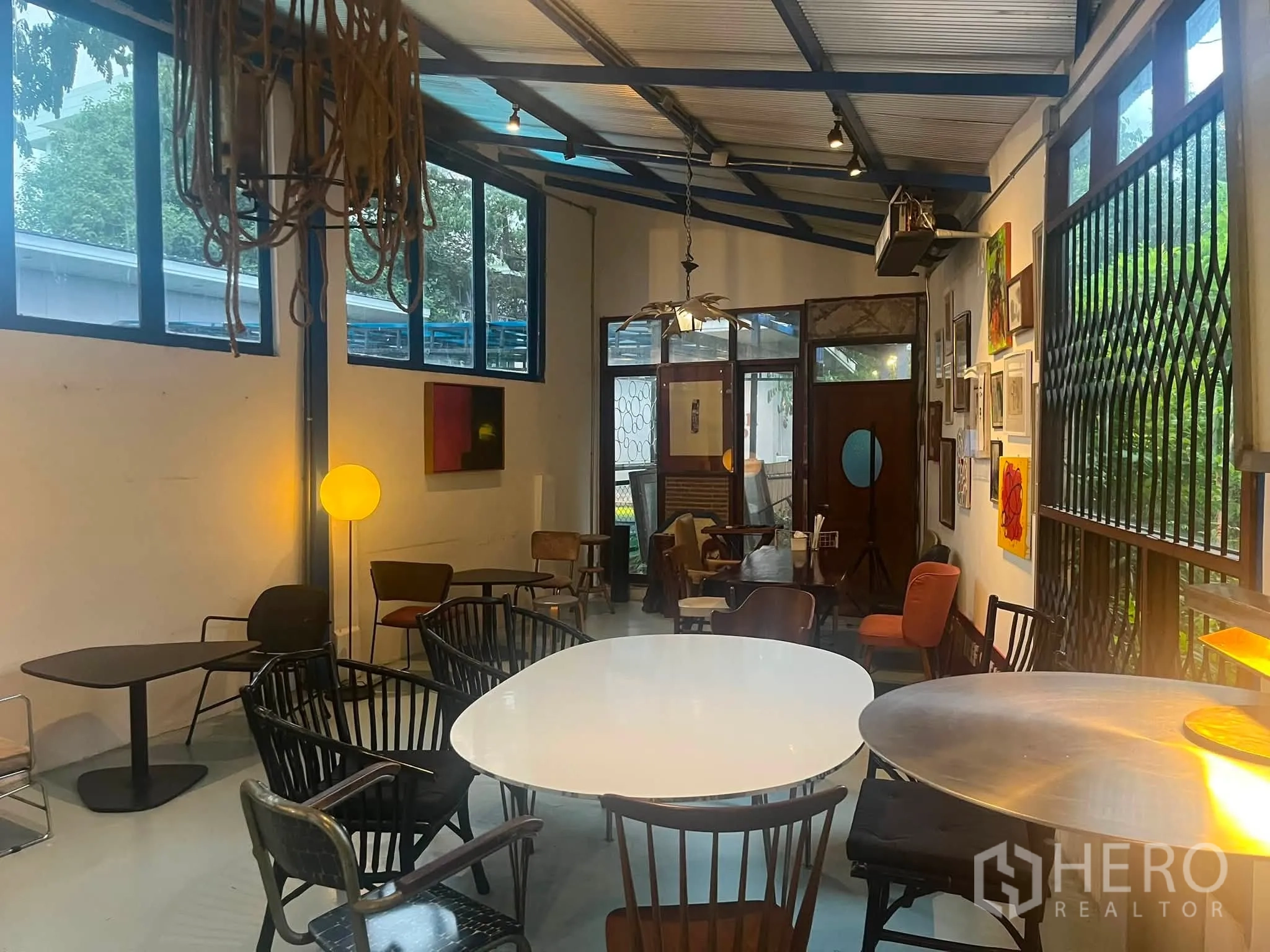 Retail Space for rent in Watthana, Bangkok - Bright indoor seating area with pendant lighting and gallery-style art on white walls.