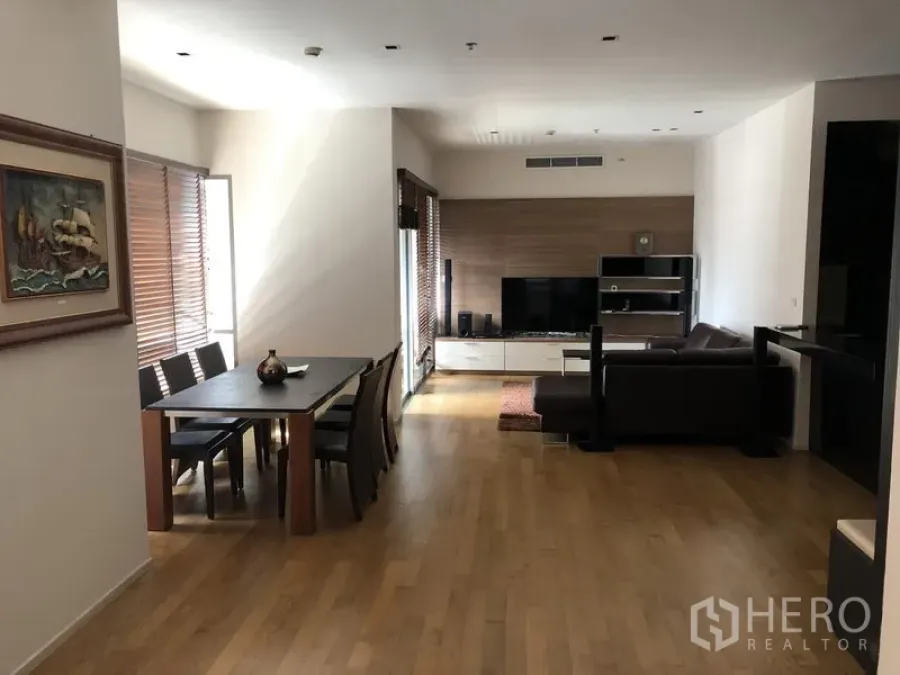 Condominium for rent in Watthana, Bangkok - Open-plan living and dining room with wood flooring, TV wall and L-shaped sofa at The Madison near Phrom Phong.