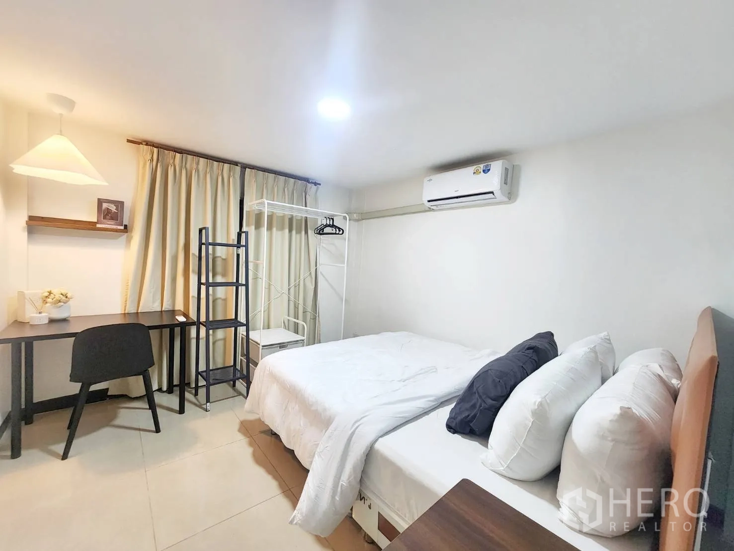 Detached House for rent in Huai Khwang, Bangkok - Bright bedroom with double bed, air conditioner, study desk, and storage rack.
