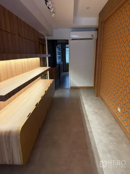 Shophouse for rent - Long workspace with illuminated wood shelves, feature lattice wall, and wall-mounted air conditioner.