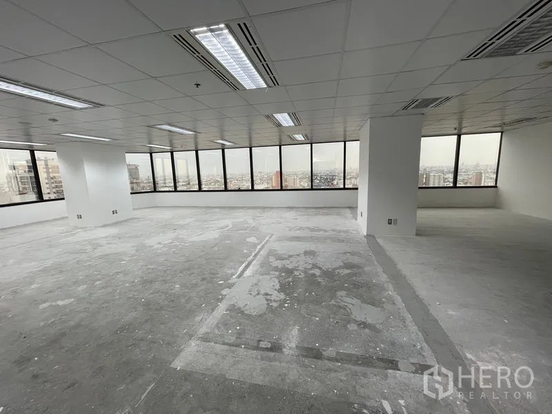 Office Space for rent in Din Daeng, Bangkok - Open office layout with panoramic glazing and concrete subfloor awaiting new finishes.
