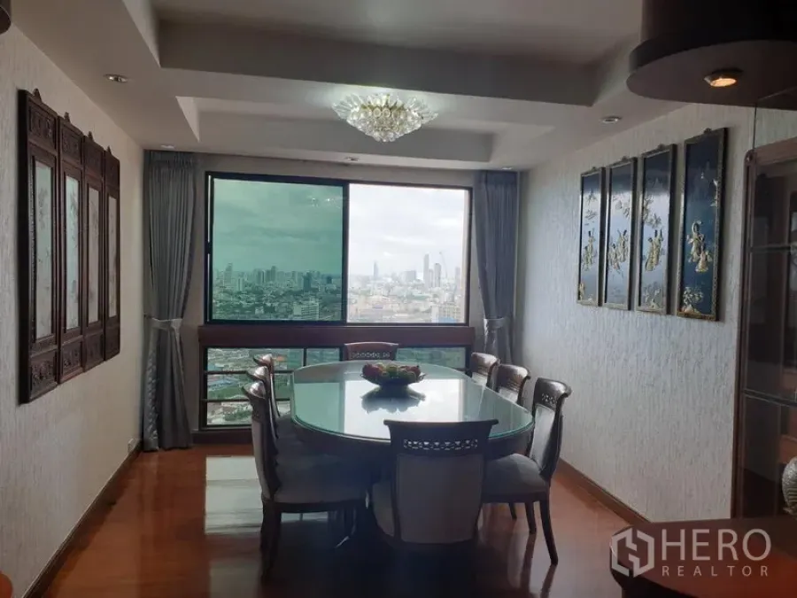 Condominium for rent in Khlong Toei, Bangkok - Dining room with chandelier, glass-top table and expansive city views through a picture window.