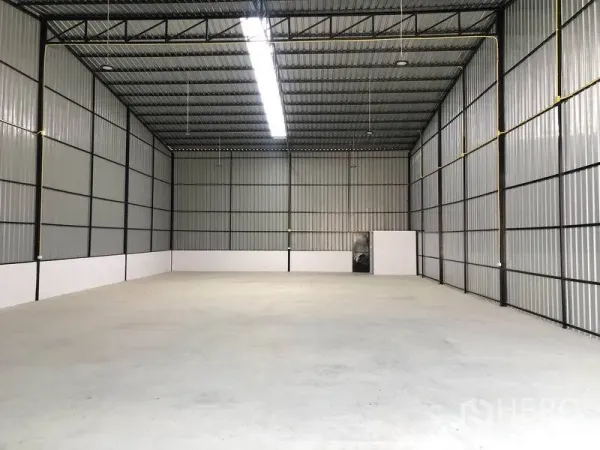 Warehouse for rent in Pathum Thani - Spacious warehouse interior with high steel truss roof, skylight strip and polished concrete floor.