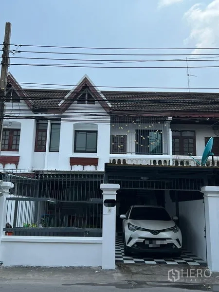 Townhouse for rent in Din Daeng, Bangkok - Townhouse exterior with gabled roof and gated covered carport.