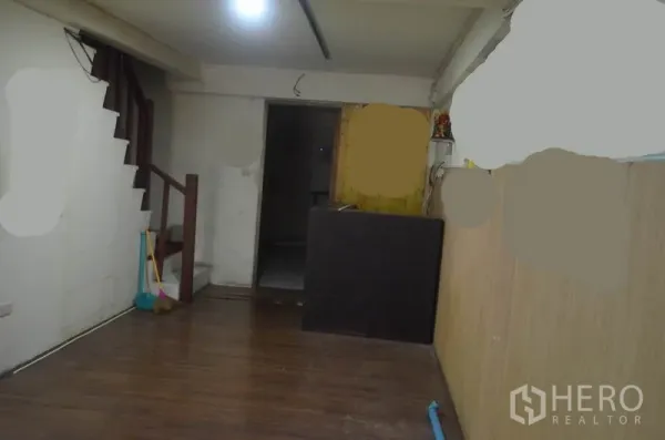 店屋 出租在Khlong Toei, Bangkok - 一层室内，木纹地板、楼梯与服务台。