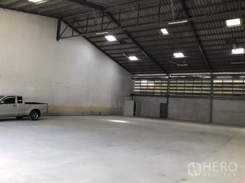 Warehouse for rent in Bang Phli, Samut Prakan - Spacious warehouse interior in Bang Phli with high steel-truss roof, skylights and concrete floor.
