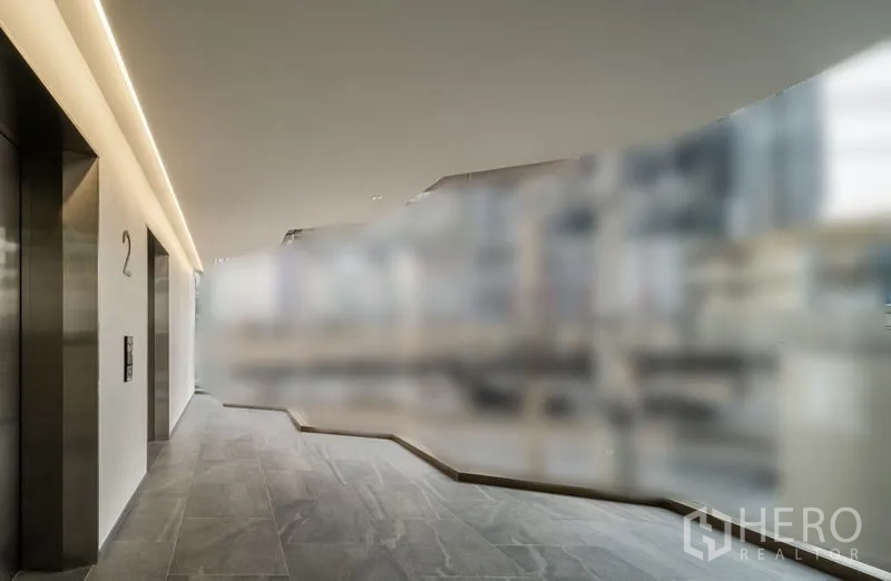 Office Space for rent in Bang Kapi, Bangkok - Elevator lobby with stone tile flooring, stainless steel elevators, and soft strip lighting.