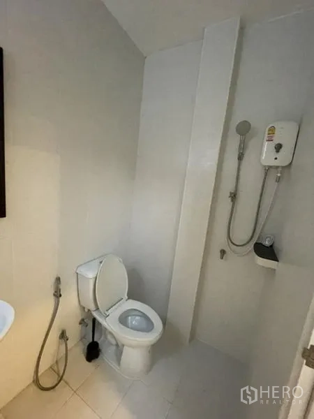 Townhouse for rent in Phra Khanong, Bangkok - Simple bathroom with shower, toilet and wall-mounted water heater.