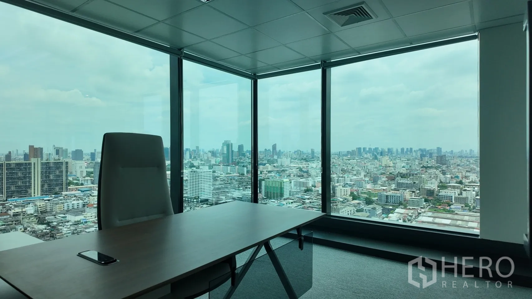 Office Space for rent in Din Daeng, Bangkok - Corner executive office with a large desk and expansive skyline views through floor-to-ceiling windows.