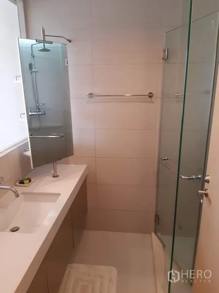 Condominium for rent in Khlong Toei, Bangkok - Clean bathroom featuring a glass-enclosed shower, long vanity and wall mirror.