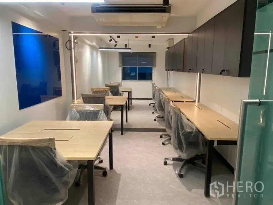 办公空间 出租在Khlong Toei, Bangkok - 现代45平米办公室，长木质工位、带轮椅子、顶柜、轨道灯与玻璃入门