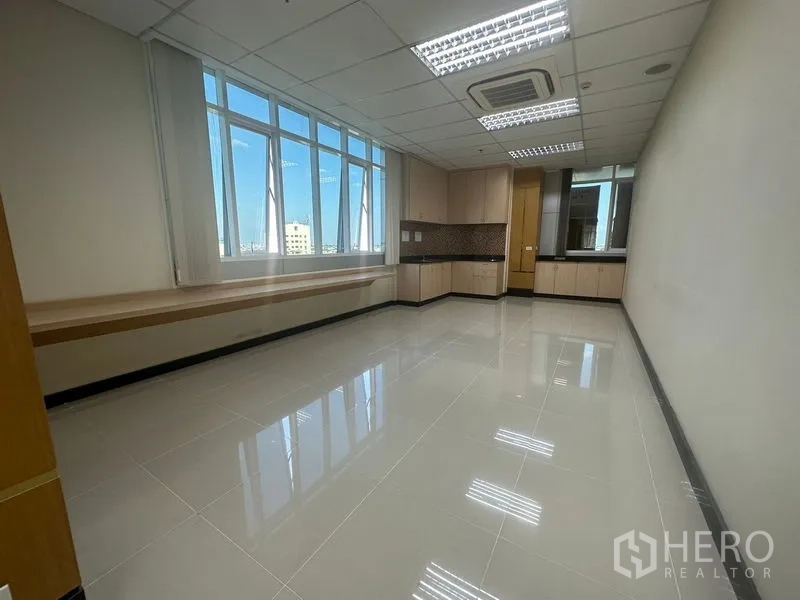 办公空间 出租在Suan Luang, Bangkok - 阳光充足的协作区，书桌、整面书架与玻璃隔断。