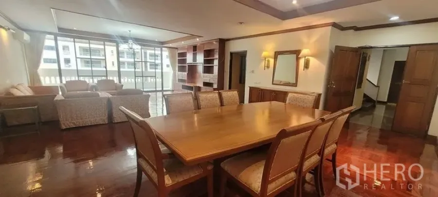 Condominium for rent in Watthana, Bangkok - Large dining and living area with six-seat table, sofa set and wide glazed doors to the balcony.