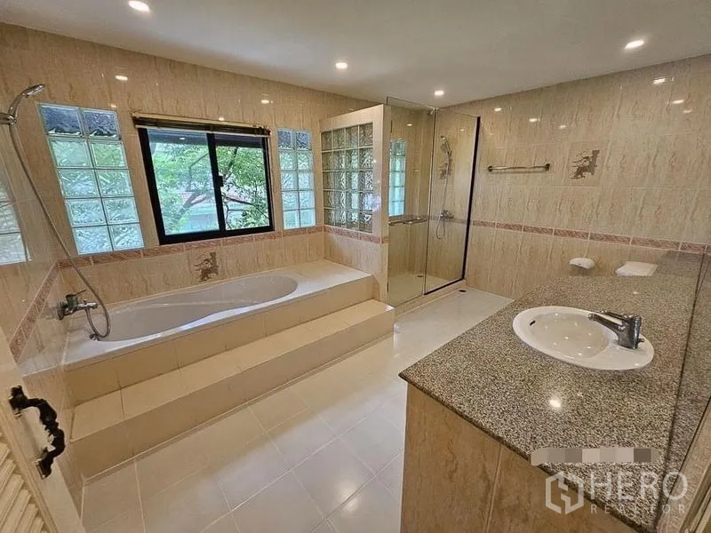 Detached House for rent - Large bathroom with raised bathtub, glass-enclosed shower, and long granite vanity.