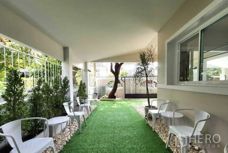 Detached House for rent in Lam Luk Ka, Pathum Thani - Covered patio with seating area along landscaped green space.