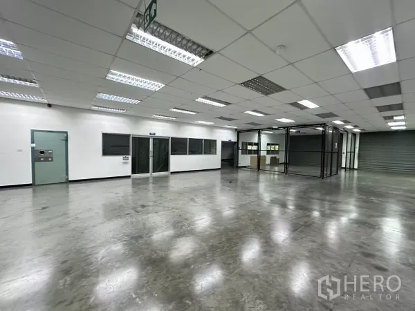 工厂 出售在Lat Krabang, Bangkok - 开放式工作区，玻璃隔间、紧急出口标识与卷闸门。