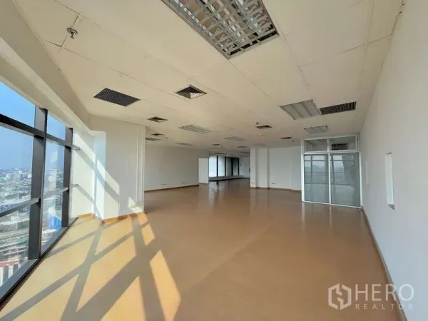 Office Space for rent in Chatuchak, Bangkok - Open-plan office with wood floors, drop ceiling lighting, and corner windows overlooking the Bangkok skyline.