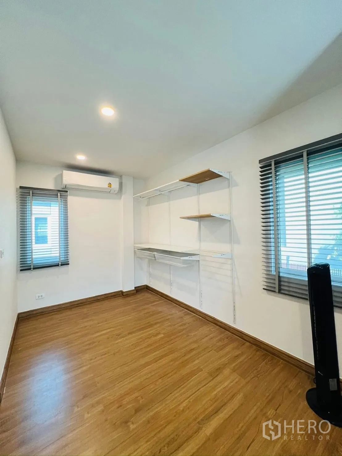 Detached House for rent in Prawet, Bangkok - Empty room with AC, twin windows and open shelving suitable as a study or bedroom.