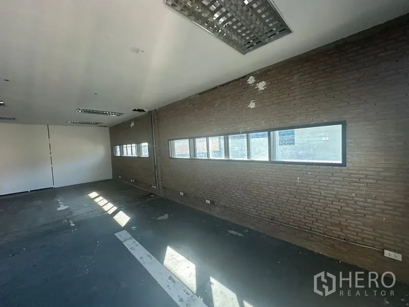 Warehouse for rent in Saphan Sung, Bangkok - Brick feature wall with narrow ribbon windows along office space.