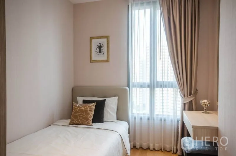 Condominium for rent or sale in Watthana, Bangkok - Second bedroom with single bed, bedside table and tall window.