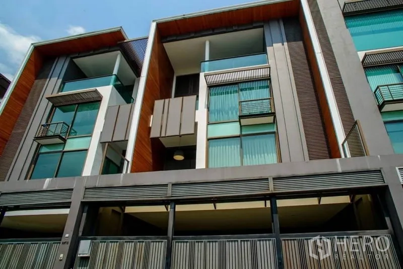 Townhouse for rent or sale in Watthana, Bangkok - Modern multi-storey townhouse facade with glass balconies and gated parking