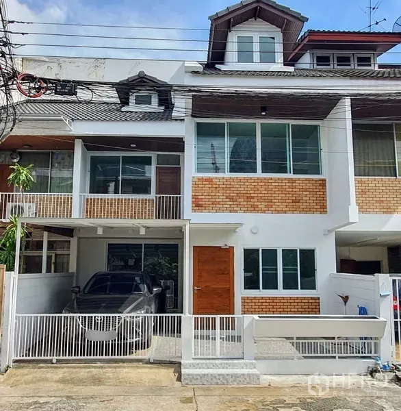 Townhouse for rent in Phaya Thai, Bangkok - Renovated three-storey townhouse in Ari with brick-and-white facade, gated carport and large windows.