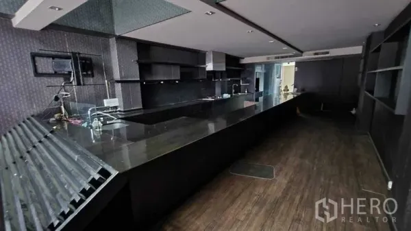 Shophouse for rent in Khlong Toei, Bangkok - Long dark stone bar counter with open shelving and service area, suitable for a restaurant or cafe.