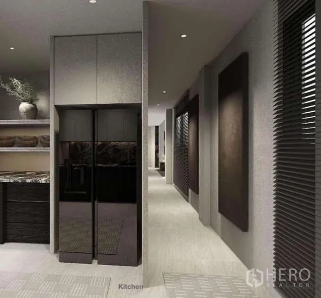 Townhouse for rent in Suan Luang, Bangkok - Alternate view of the kitchen hallway with cabinetry and integrated fridge.