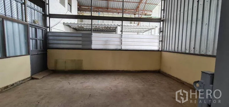Warehouse for rent in Pak Kret, Nonthaburi - Enclosed side room with windows and metal cladding suitable for extra storage or staff use.