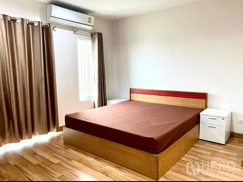Townhouse for rent in Suan Luang, Bangkok - Master bedroom with large bed, air conditioner, and natural light.