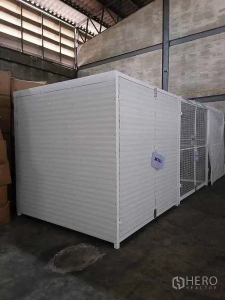 Factory for rent in Bang Phli, Samut Prakan - Secure white storage cage within a high-ceiling warehouse space.