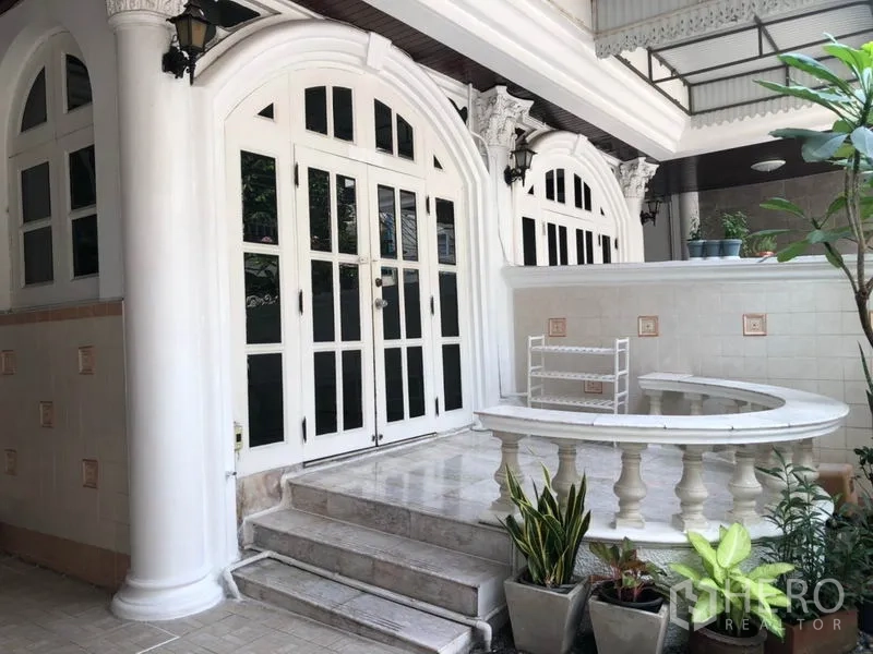 Townhouse for rent in Khlong Toei, Bangkok - Front porch with white columns, arched French doors, tiled steps and planter.