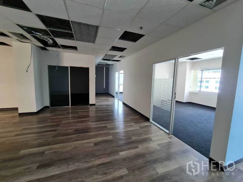 Office Space for rent in Watthana, Bangkok - Hallway area leading to glass meeting rooms with carpet, alongside wood floors and bright windows.