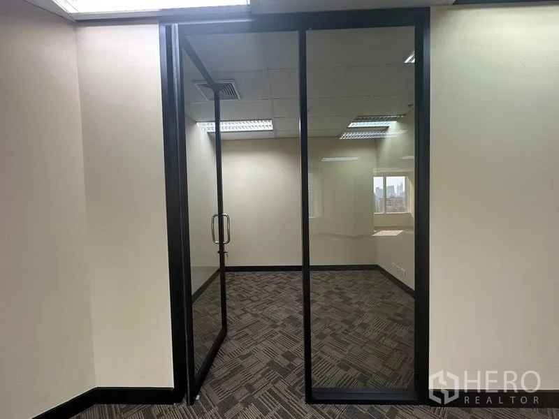 Office Space for rent - Compact glass-partitioned office room with a door and carpet flooring.