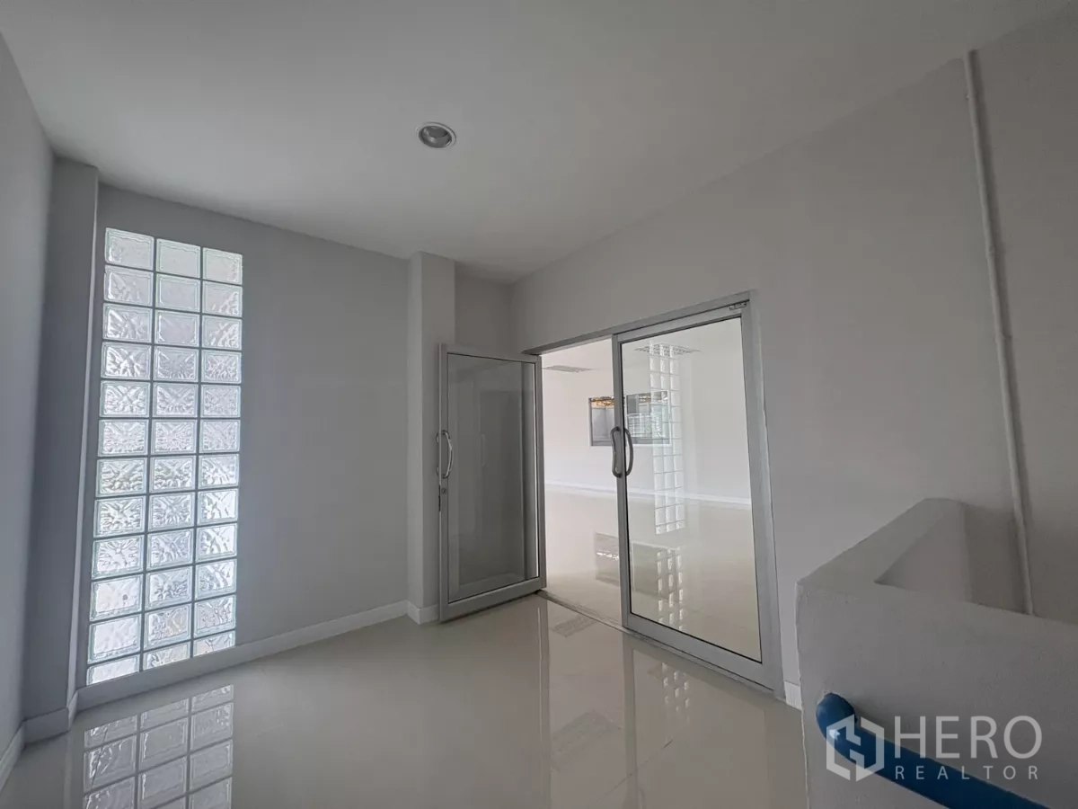 Factory for rent in Bang Phli, Samut Prakan - Entrance lobby featuring a glass-block wall and sliding glass doors to the office area.