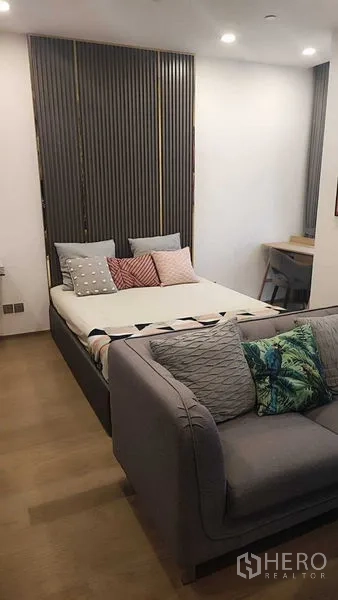 Condominium for rent in Bang Rak, Bangkok - Studio-style layout showing bed next to sofa and a work desk.