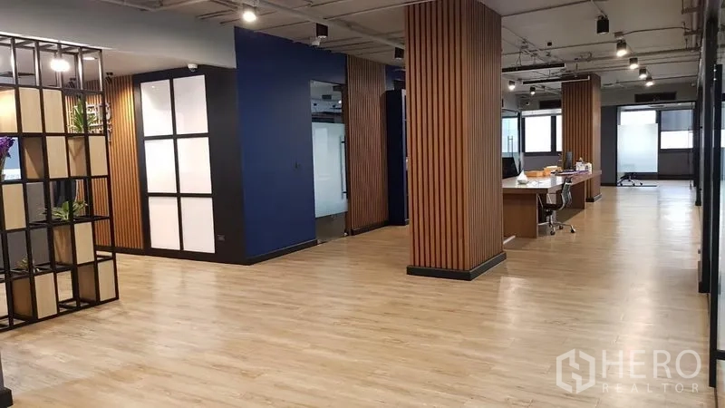 Office Space for rent in Khlong Toei, Bangkok - Open-plan office with wood slat columns, task lighting and shared desks on light wood floors.